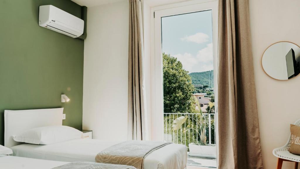 En eller flere senge i et værelse på Villa Viola Rooms, a 200mt dalla spiaggia di Procchio