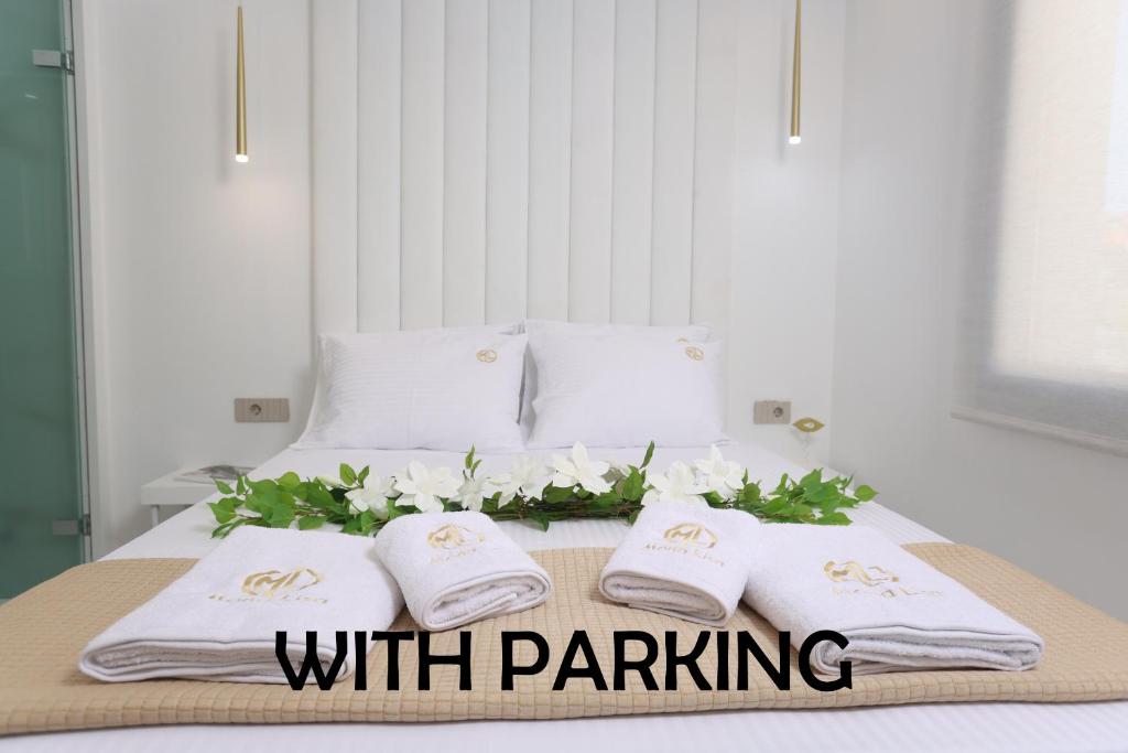 a bed with two towels and flowers on it at Mona Lisa in Pefkochori