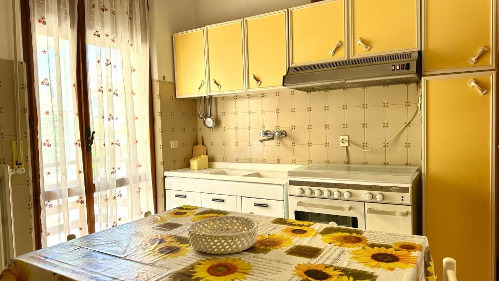 a kitchen with a table with flowers on it at SE081 - Comodo trilocale a Marotta in Marotta