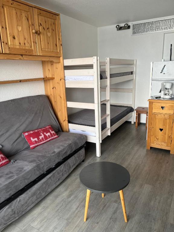 a room with two bunk beds and a couch and a table at Ancolie in Villarembert