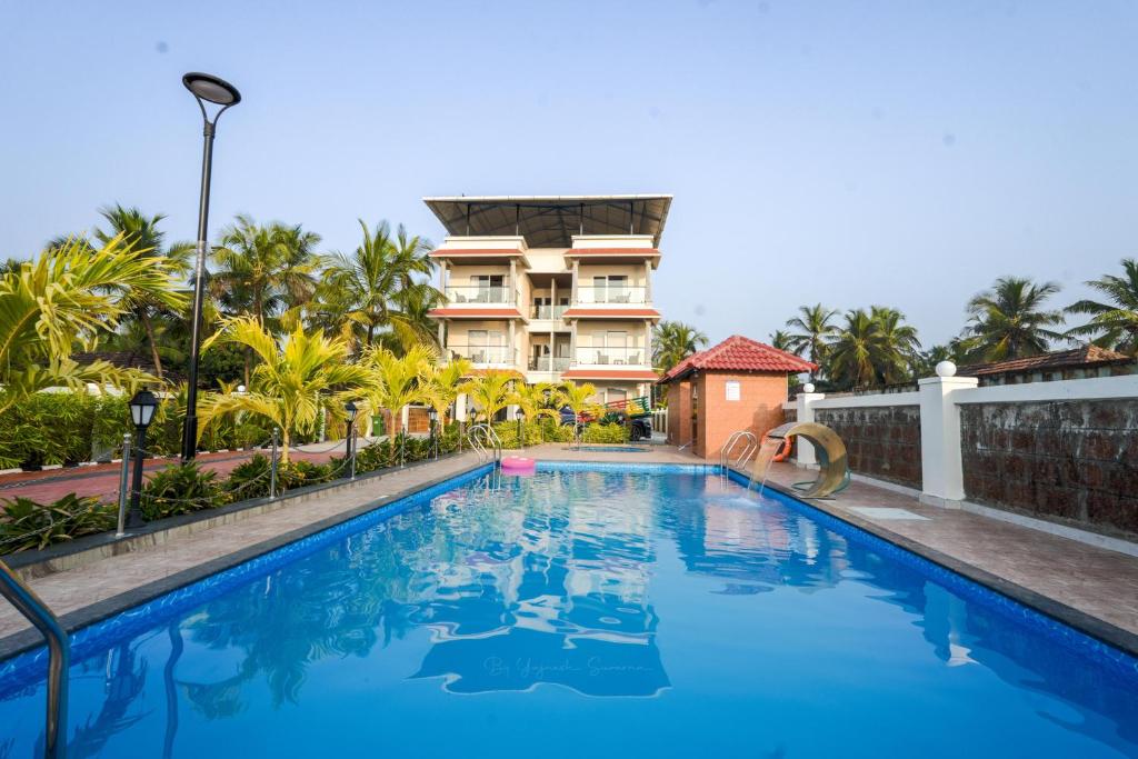 a swimming pool in front of a building at Casa Marina Beachfront Resort in Padubidri