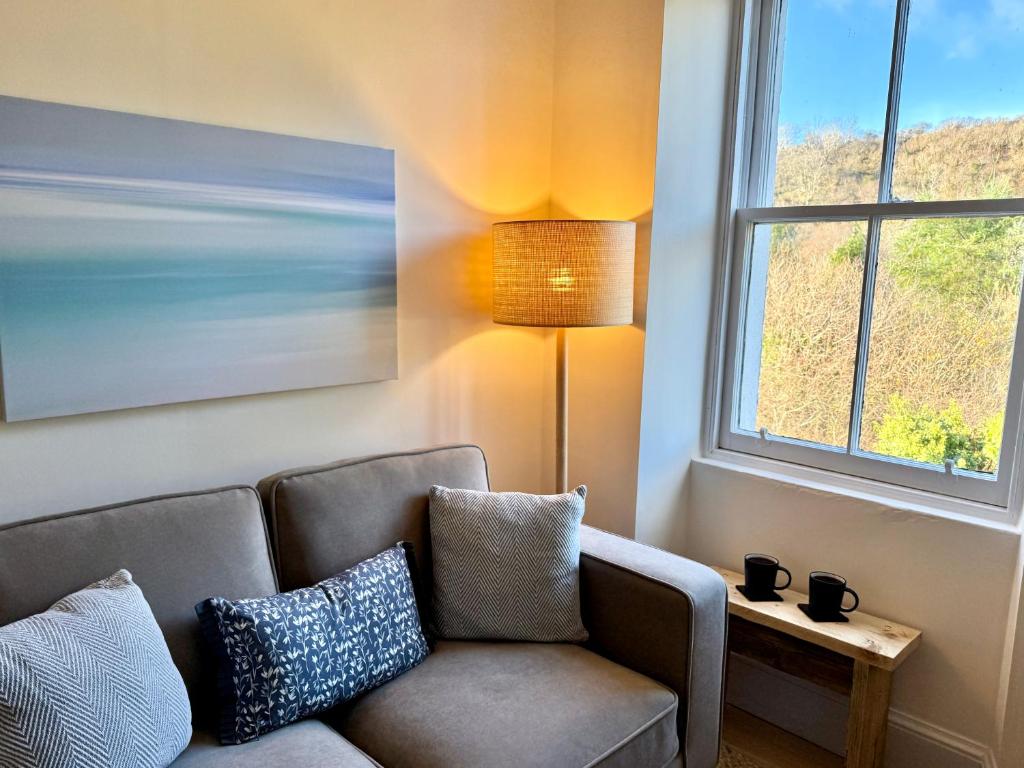 ein Wohnzimmer mit Sofa und Fenster in der Unterkunft Glenrigh House - Loch View Flat for 2 in Onich