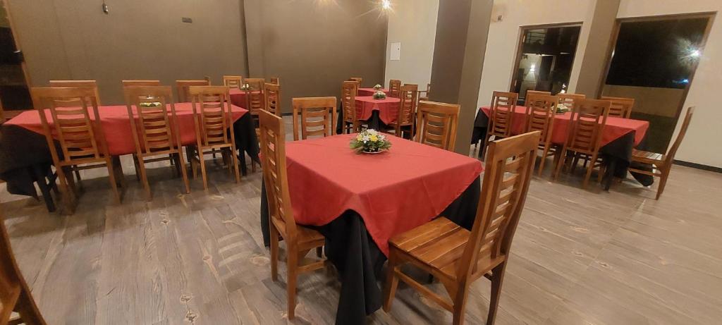 a dining room with red tables and wooden chairs at Orion Blue Hotel in Dombagahawatta