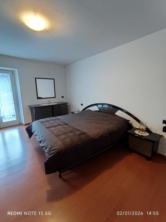 a bedroom with a bed and a tv on the wall at La casa del Gianni in Piano