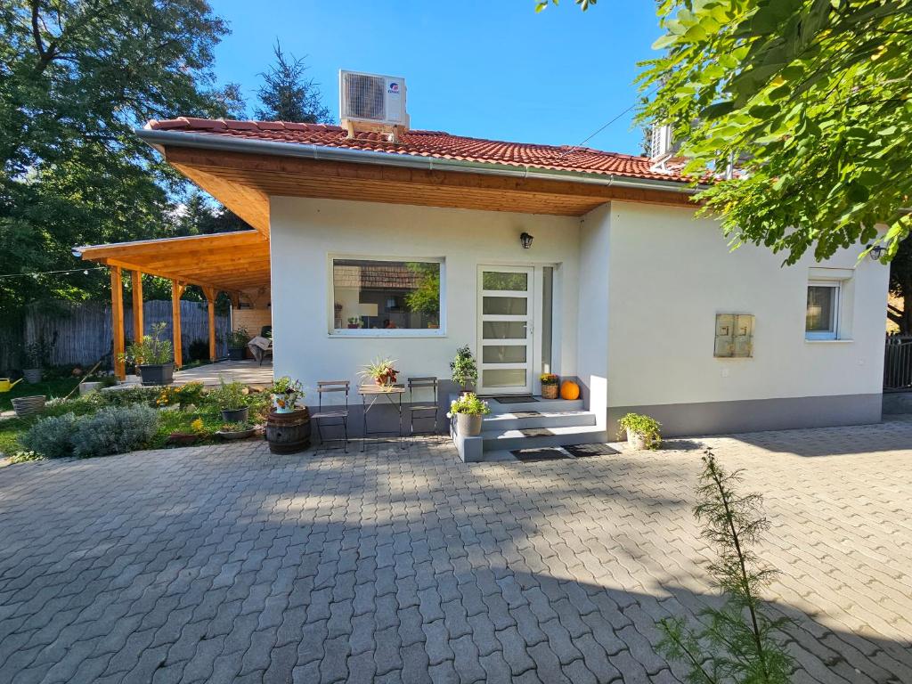 una piccola casa bianca con portico e patio di Birslak a Makkoshotyka