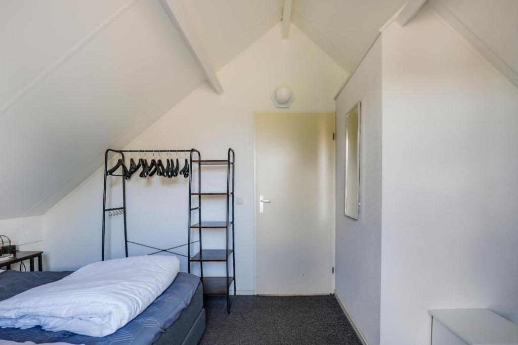 a room with a ladder and a bed in a attic at 6 - Person Lake Area 28 Bungalow in Ewijk