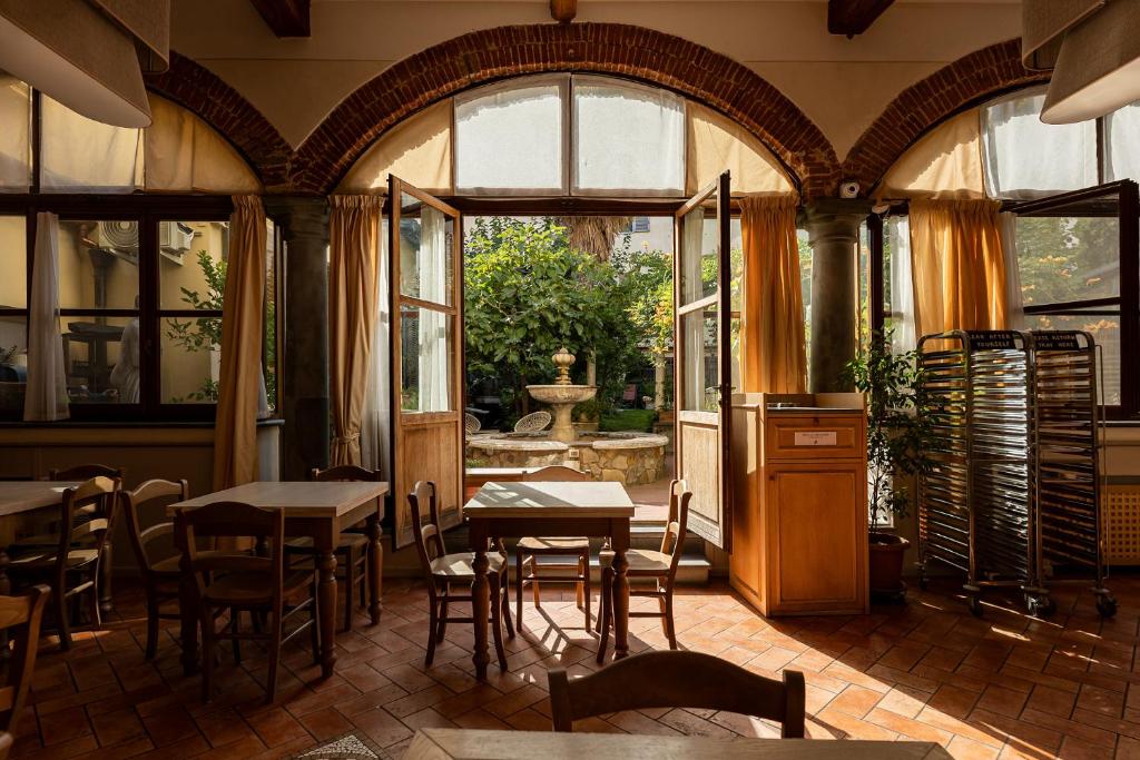 een restaurant met tafels en stoelen en een groot raam bij Hostel Archi Rossi in Florence