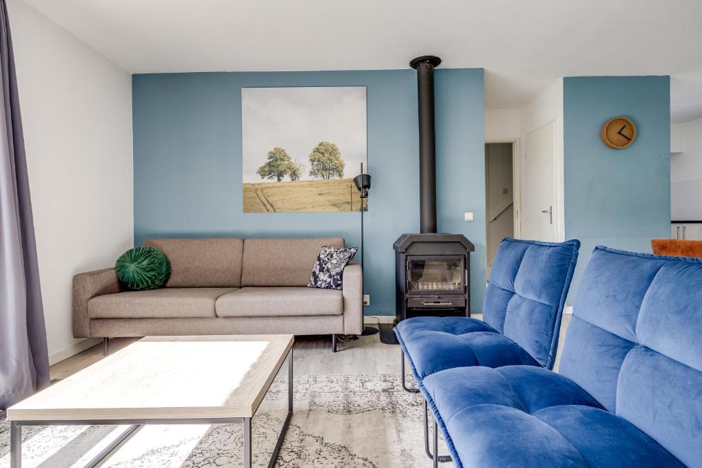 a living room with blue chairs and a couch at 5 - Person Forest 239 Sauna Bungalow in Ewijk