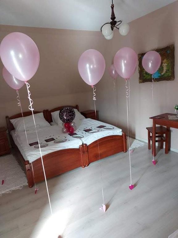 a bedroom with pink balloons on a bed at Liebner-kerti Vendégház in Kakucs