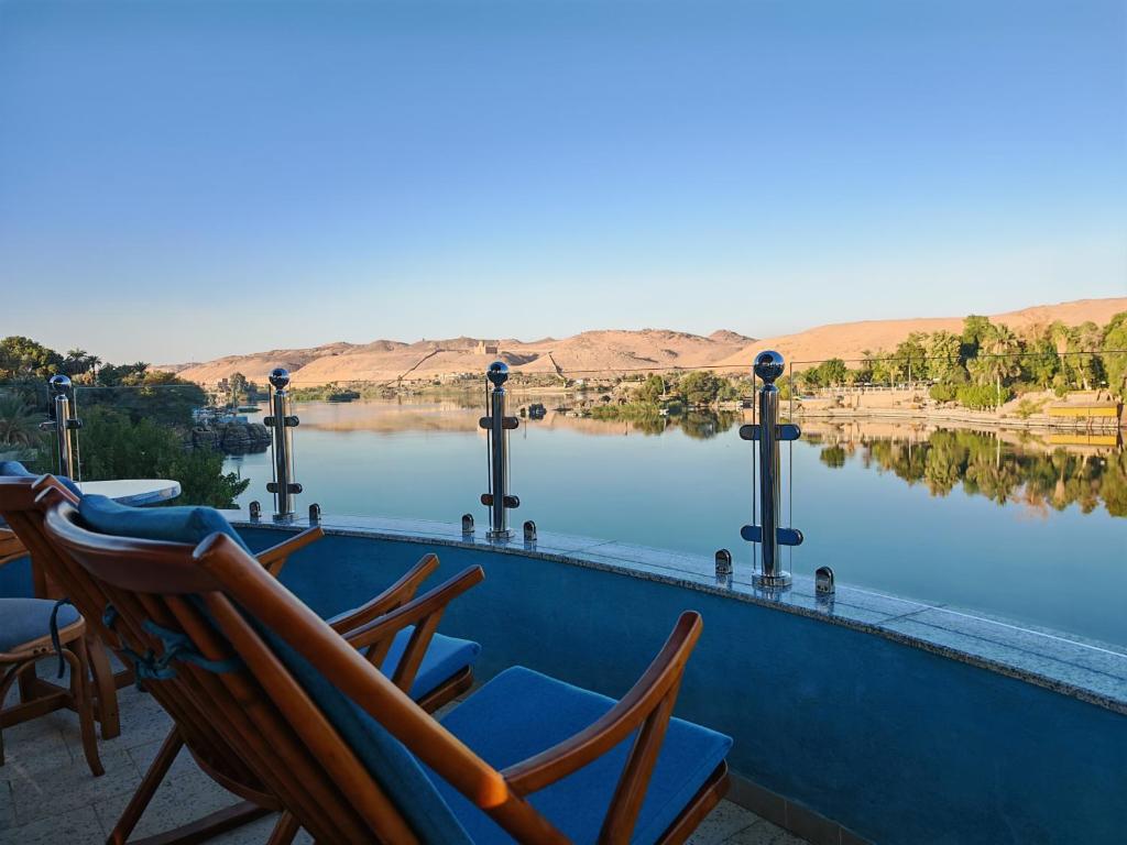 a group of chairs sitting on the edge of a swimming pool at Villa Swenet in Aswan
