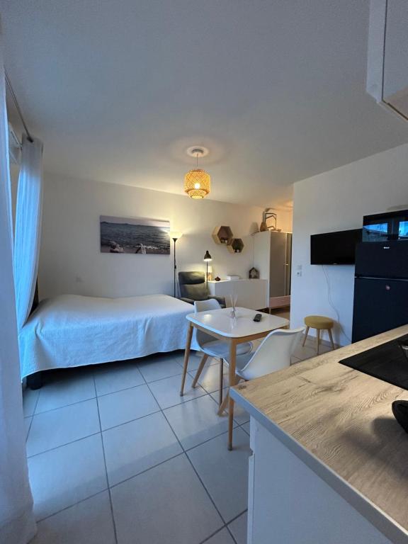 a hotel room with a bed and a table and chairs at Studio a 3 mn à pied des thermes in Balaruc-les-Bains