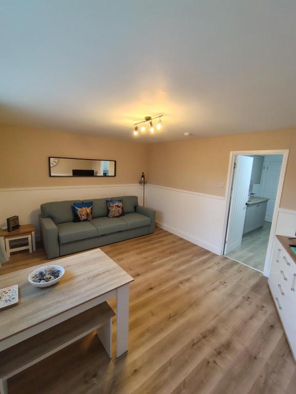 a living room with a couch and a table at Millburn Chalet in Inverkip
