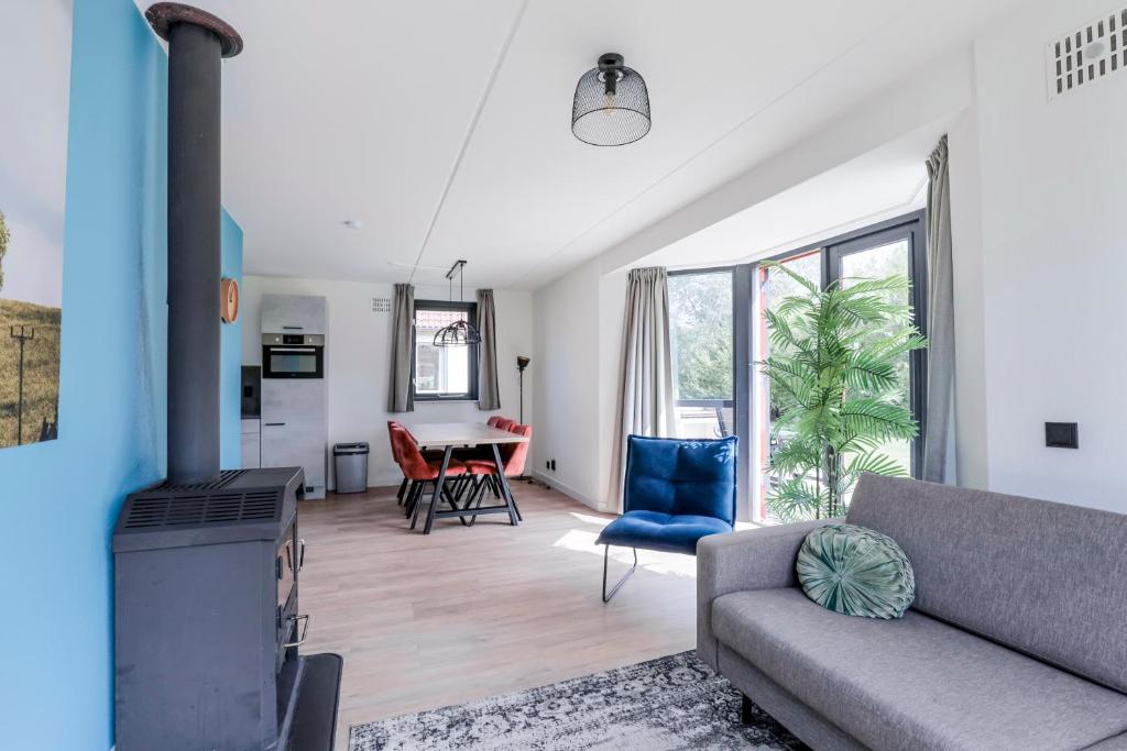 a living room with a couch and a fireplace at 6 - Persons Lakeside 25 Bungalow in Ewijk