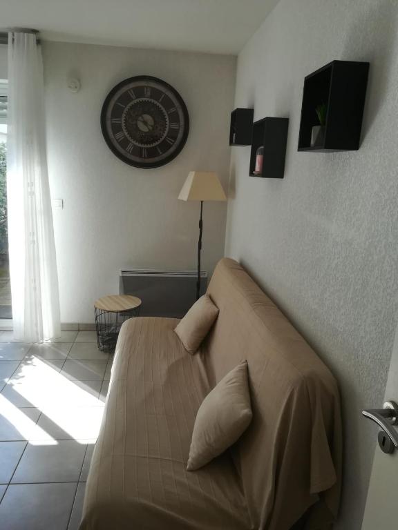 a bedroom with a bed and a clock on the wall at Residencia Odyssee in Vieux-Boucau-les-Bains