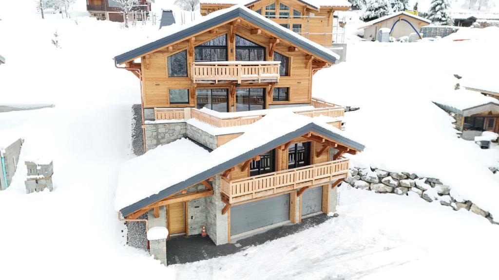 a log home in the snow with four different views at Chalet APY - Grand chalet neuf avec terrasse, 6 chambres en-suite , wifi, balcon, etc in Les Gets