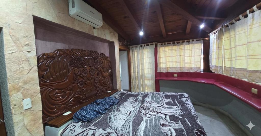 een slaapkamer met een bed met een houten hoofdeinde bij Casa El Limón in Zihuatanejo