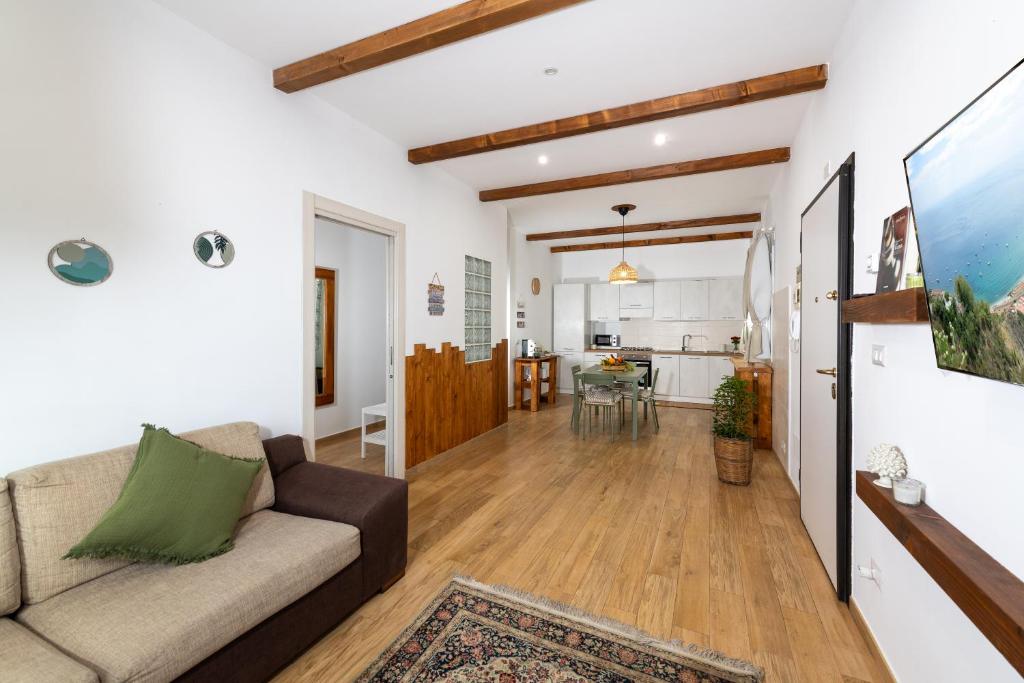 a living room with a couch and a kitchen at Agata's House in Viagrande