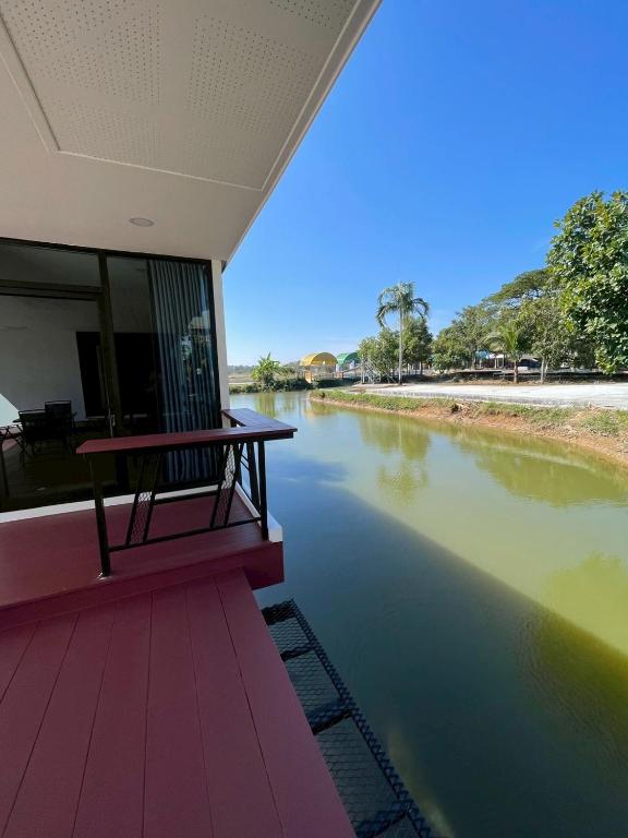 a bench sitting on a deck next to a river at The Lakefront Collective in Buriram, Thailand in Ban Nong Muang
