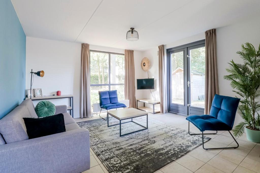a living room with a couch and blue chairs at 6 - Persoons Forest 185 Bungalow in Ewijk