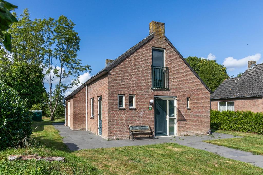 a brick house with a bench in front of it at 6 - Persoons Forest 193 Bungalow in Ewijk
