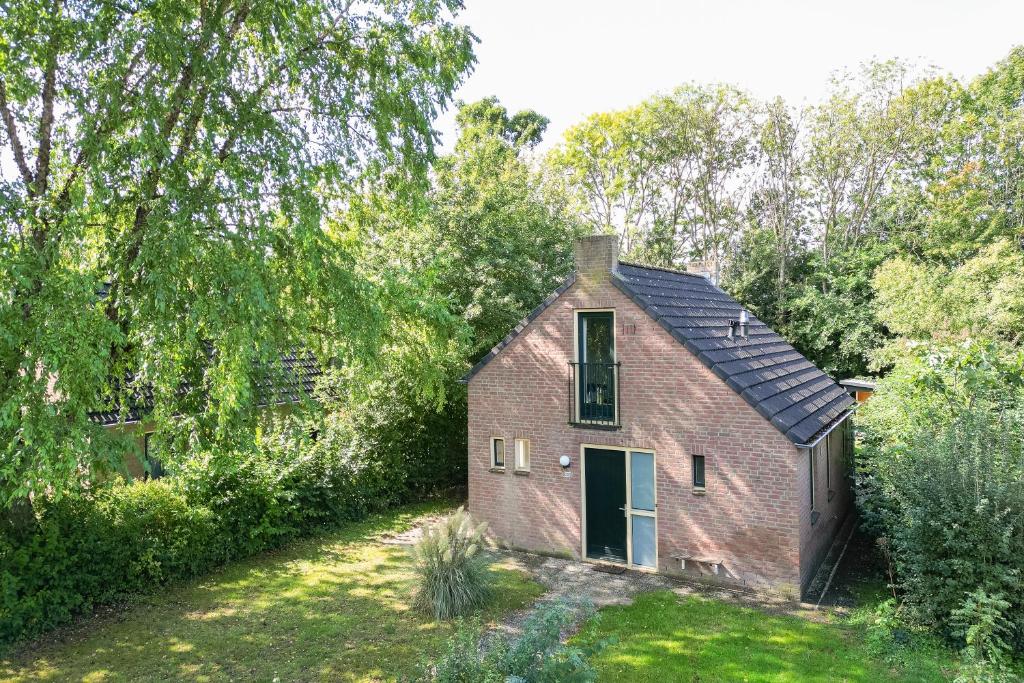 an old brick house with a black roof at 6 - Persoons Forest 209 Bungalow in Ewijk