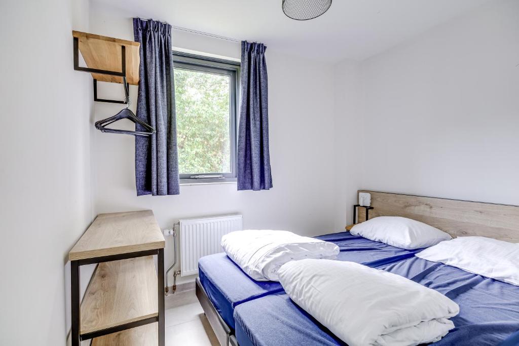 a bedroom with two beds and a window at 6 - Persons Forest 287 Bungalow in Ewijk