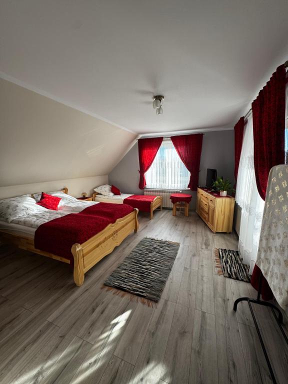 a bedroom with two beds and red curtains at Spokój u Zosi in Stare Bystre