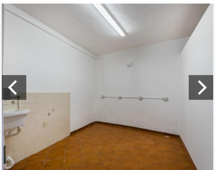 una stanza vuota con una parete bianca e un pavimento piastrellato di Casa Roró a Casale Marittimo