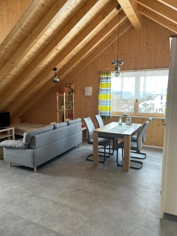 een woonkamer met een tafel en een bank bij Holzliebe mit Donaublick in Kaisheim
