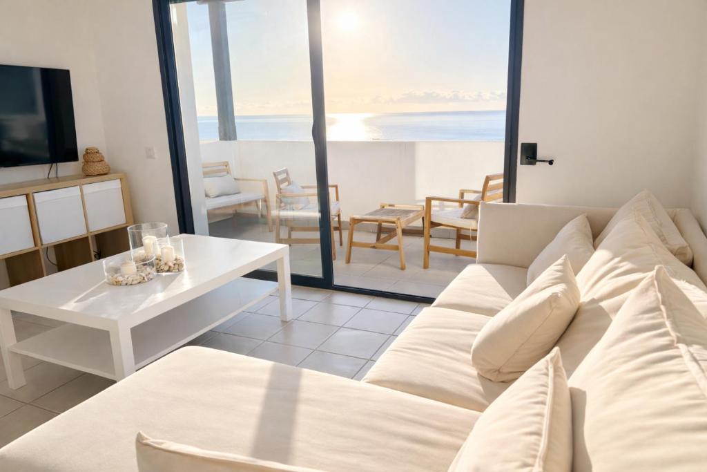 een woonkamer met een witte bank en een tafel bij Apartamento Califato 5 in Mojácar