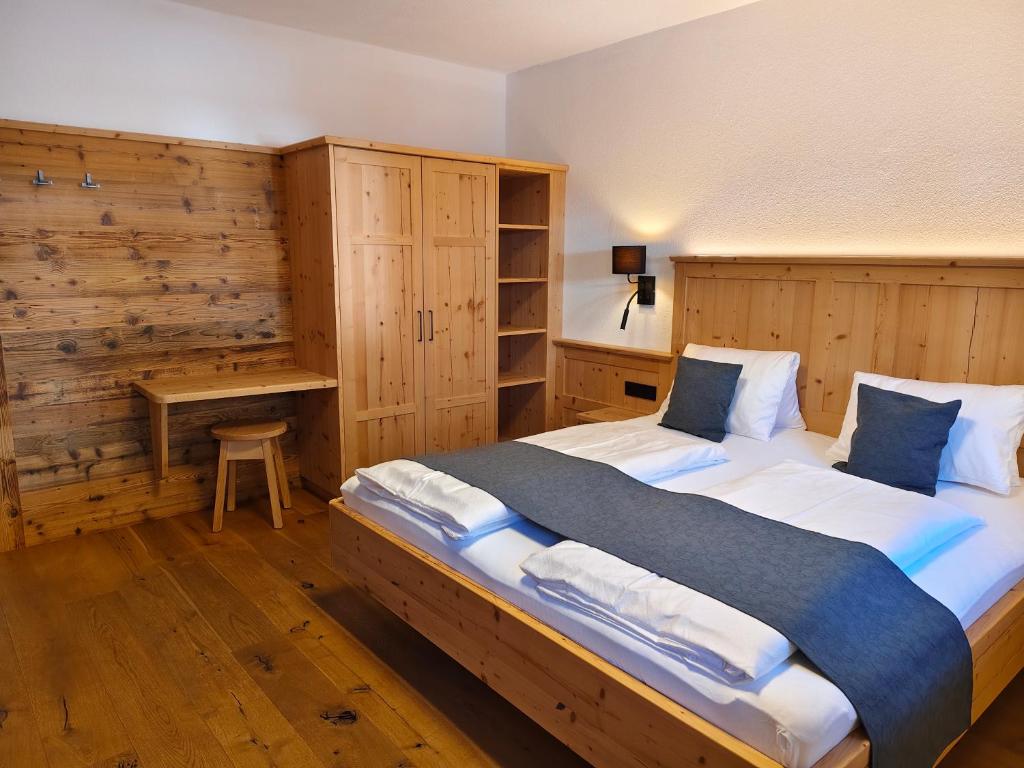 una camera da letto con un letto grande e una scrivania di Ferienhaus Veider a Obertilliach