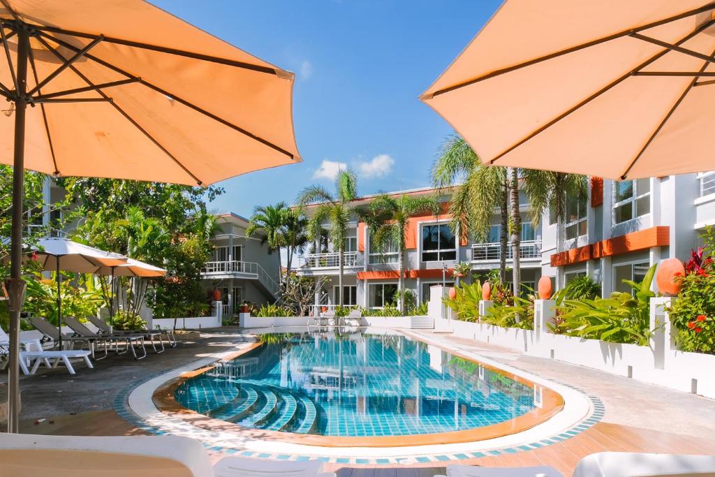 an image of a swimming pool at a hotel with umbrellas at The One Cozy, Phuket in Chalong