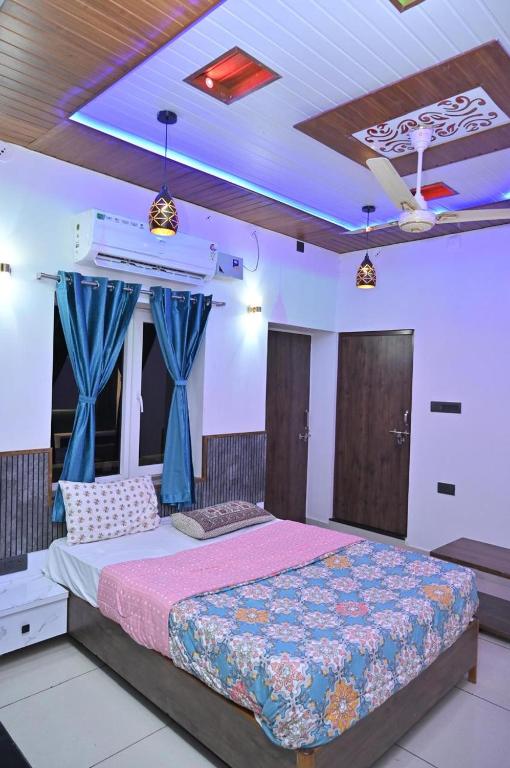 a bedroom with a large bed with blue curtains at Bhagyashree hotel & restuarant osian in Osiān