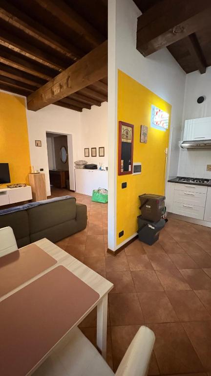 a living room with a couch and a yellow wall at Residenza Marconi centro storico in Budrio