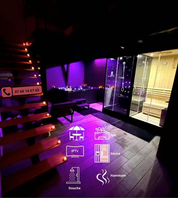a stage with purple lights and a table and chairs at Love Room Spa - Sauna - Hammam in Domérat