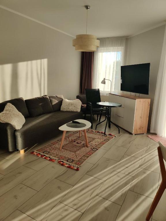 a living room with a couch and a table at Apartament Charlie in Darlowko