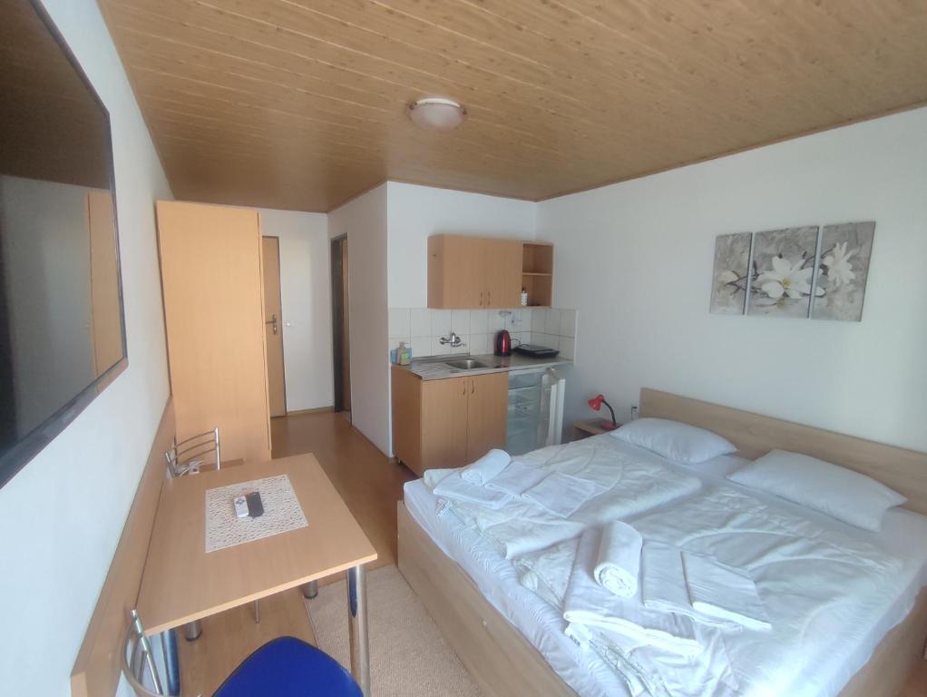 a small bedroom with a bed and a table at Ubytovanie Erika in Vitanová