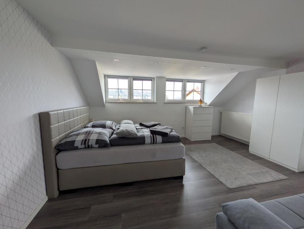 een slaapkamer met een bed in een witte kamer bij FeWo Luzia in Losheim