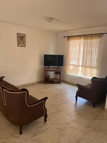 a living room with two chairs and a flat screen tv at Casa Completa Cómoda en el Sur in Santa Gertrudis
