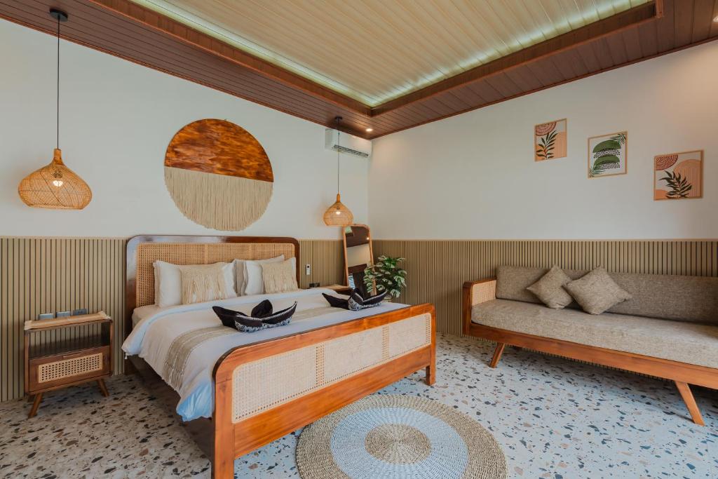 a bedroom with a bed and a couch at Pondok loji villa in Ubud