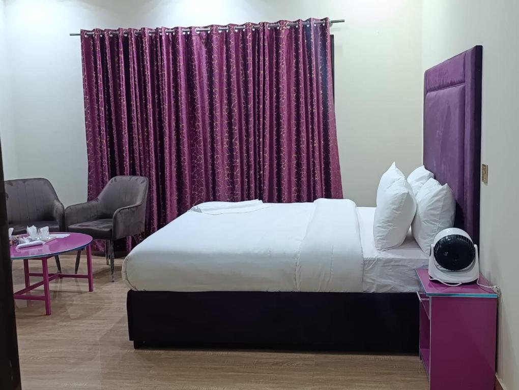 a bedroom with a bed and a purple curtain at Emporia Hotel & Suites in Lahore