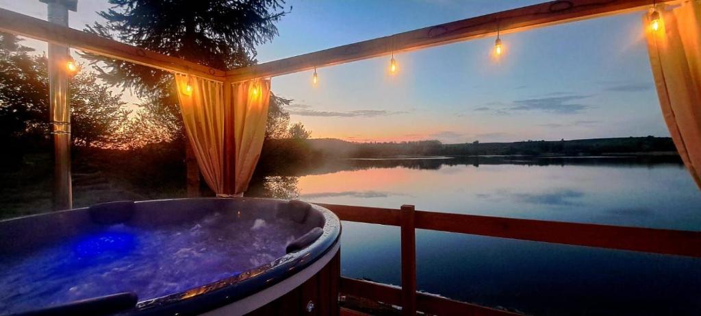 a bath tub with a view of a lake at Wilczy Domek nad Witką in Wilka