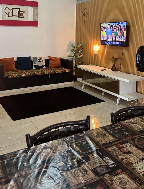 a living room with a couch and a tv at Hostel Mariah in Cabo Frio