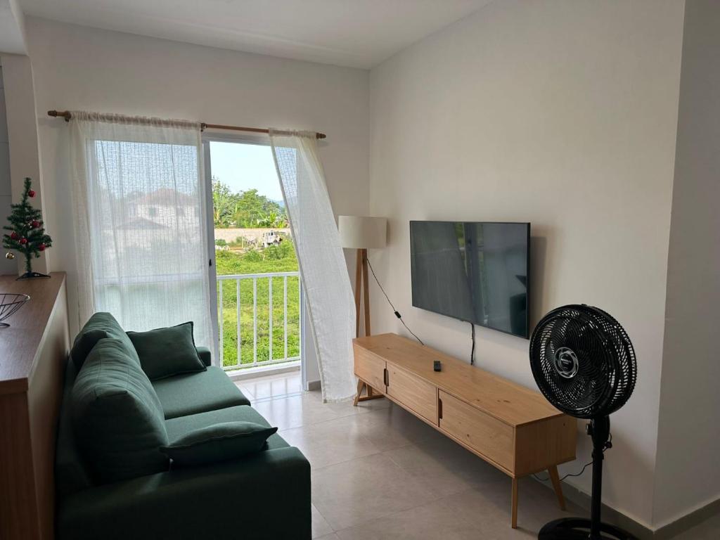 a living room with a couch and a flat screen tv at Apartamento 2 Quartos com Ar Condicionado in Paraty