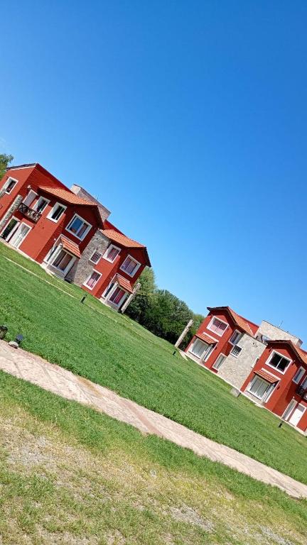two buildings on a grassy hill next to a field at Alma Apart in Los Molles