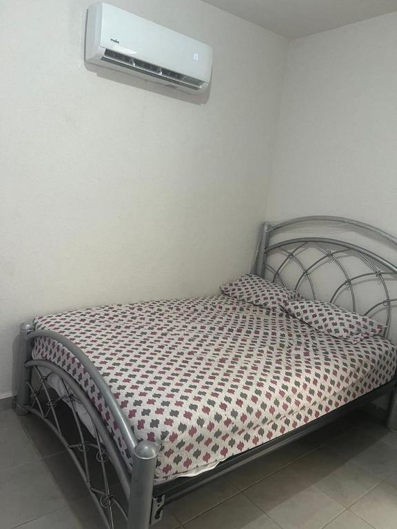 a bedroom with a bed with a air conditioner on the wall at Tu hogar en acapulco in General Juan N Alvarez International Airport