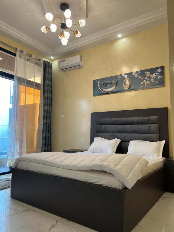 una camera da letto con un letto grande in una stanza di Residence Ndeye Ngouye a Dakar