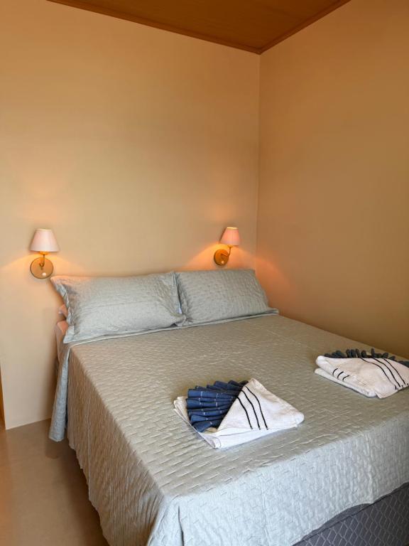 a bedroom with a bed with two towels on it at Casa Sol da Ilha in Angra dos Reis