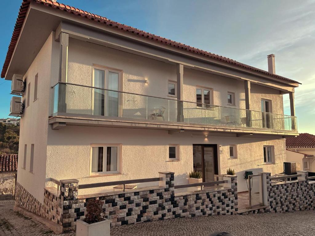 a house with a balcony on top of it at Hostel Rosa in São Pedro de Moel