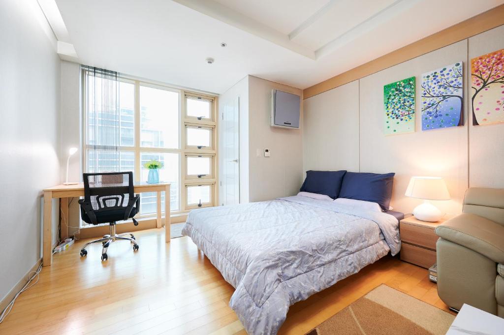 a bedroom with a bed and a desk and a chair at Gangnam Opal in Seoul